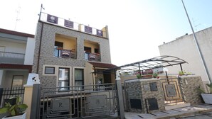 A two-story building with a balcony, a gated entrance, and a small covered area with potted plants. - B&B Sant'oronzo Turi (Turi)