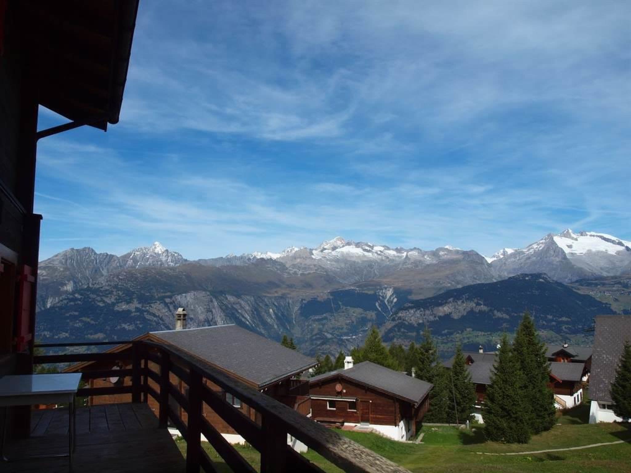Bergblick mit einem Holzhäuschen und einem Balkon.