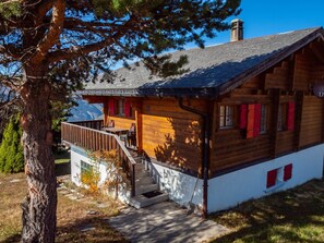 Eine Holzhütte mit Balkon, Treppe und Bergblick.