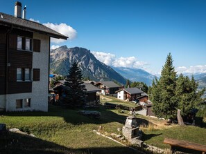 A mountain village with traditional wooden houses, a stone fireplace, and a clear view of the surrounding mountains. - Chalet Sunnuterrasse Appartement/Fewo, Dusche, WC 4-Zimmerwohnung Dusche, WC by Interhome (Rosswald)