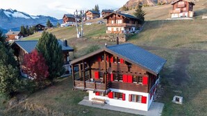 A wooden chalet with a balcony, surrounded by a mountainous landscape. - Chalet Gerbera Appartement/Fewo, Bad, WC 5-Bettwohnung by Interhome (Rosswald)