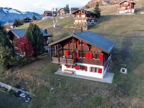A wooden chalet with a balcony, surrounded by a mountainous landscape. - Chalet Gerbera Appartement/Fewo, Bad, WC 5-Bettwohnung by Interhome (Rosswald)