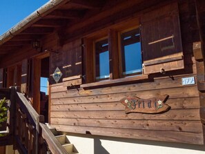Een houten gebouw met een bord waarop 'Fridi' staat en een waarschuwingsbord voor een overstekende beer.