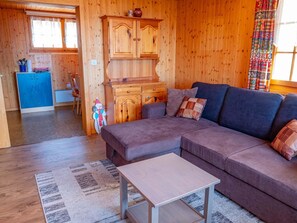 A cozy wooden interior with a sofa, a small table, and a cabinet. - Chalet Valeria 4-Bettwohnung, Parterre, 2 Schlafräume Valeria EG by Interhome (Rosswald)