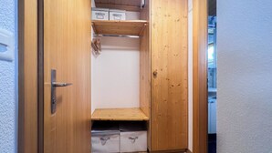 Ein Holzschrank mit Regalen und einer Tür.