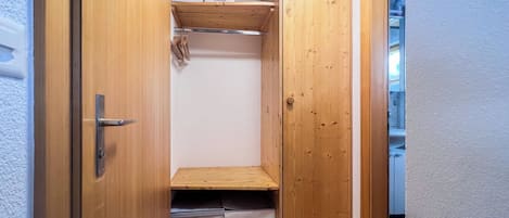Um armário de madeira com prateleiras e porta.