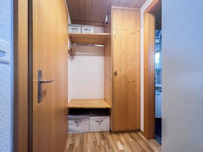 Ein Holzschrank mit Regalen und einer Tür.
