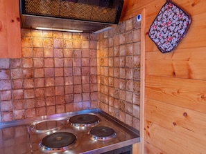 A kitchen with a tiled backsplash and a stainless steel stove. - Chalet Valeria 5-Bettwohnung, 1. Stock, 2 Schlafräume Valeria OG by Interhome (Rosswald)