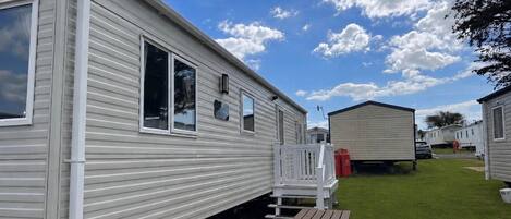 A mobile home with a patio and a small deck.