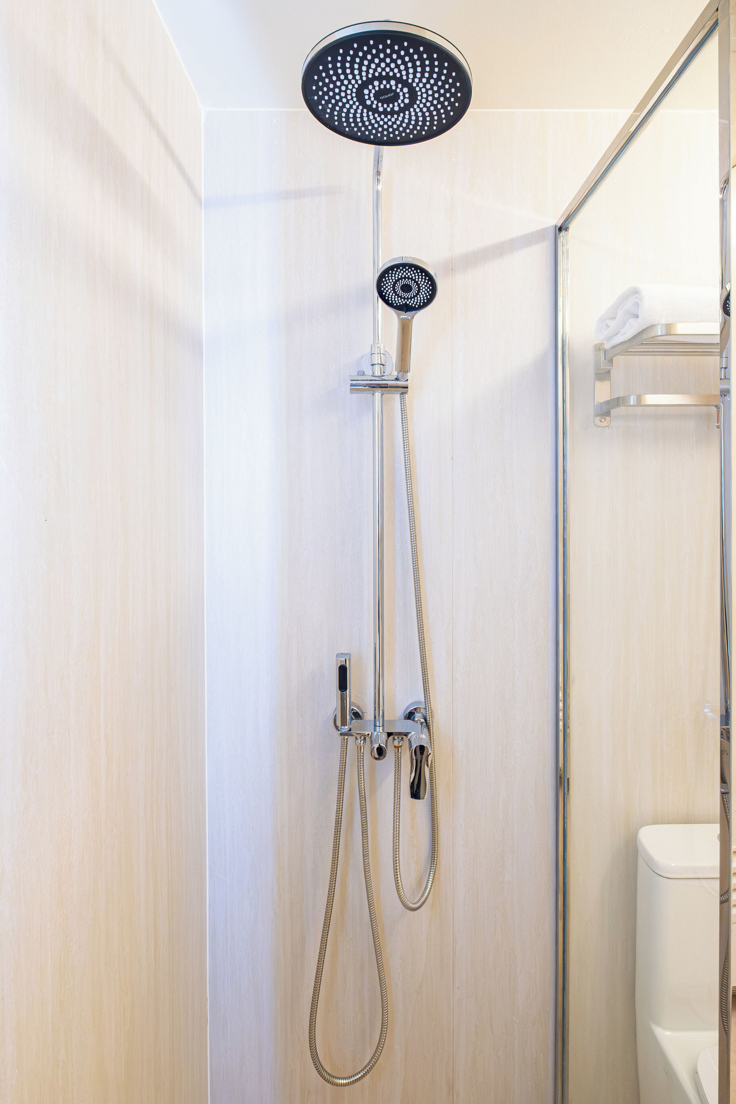 Eine moderne Dusche mit Handbrause und fest installierter Bedienung.