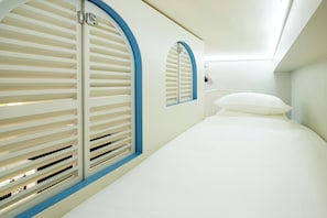 A room with a bed, a window with blinds, and a wall-mounted light fixture. - Rest Rochor Hotel (Singapore)