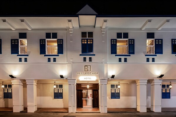A hotel facade with multiple windows, a central entrance, and a sign indicating it is a hotel. - Rest Rochor Hotel (Singapore)