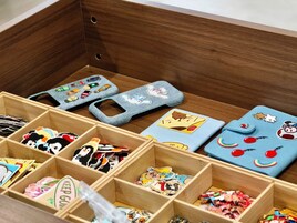 A wooden storage box with compartments containing various items.