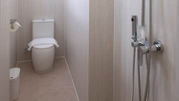 A modern bathroom with a shower, toilet, and a towel rack.