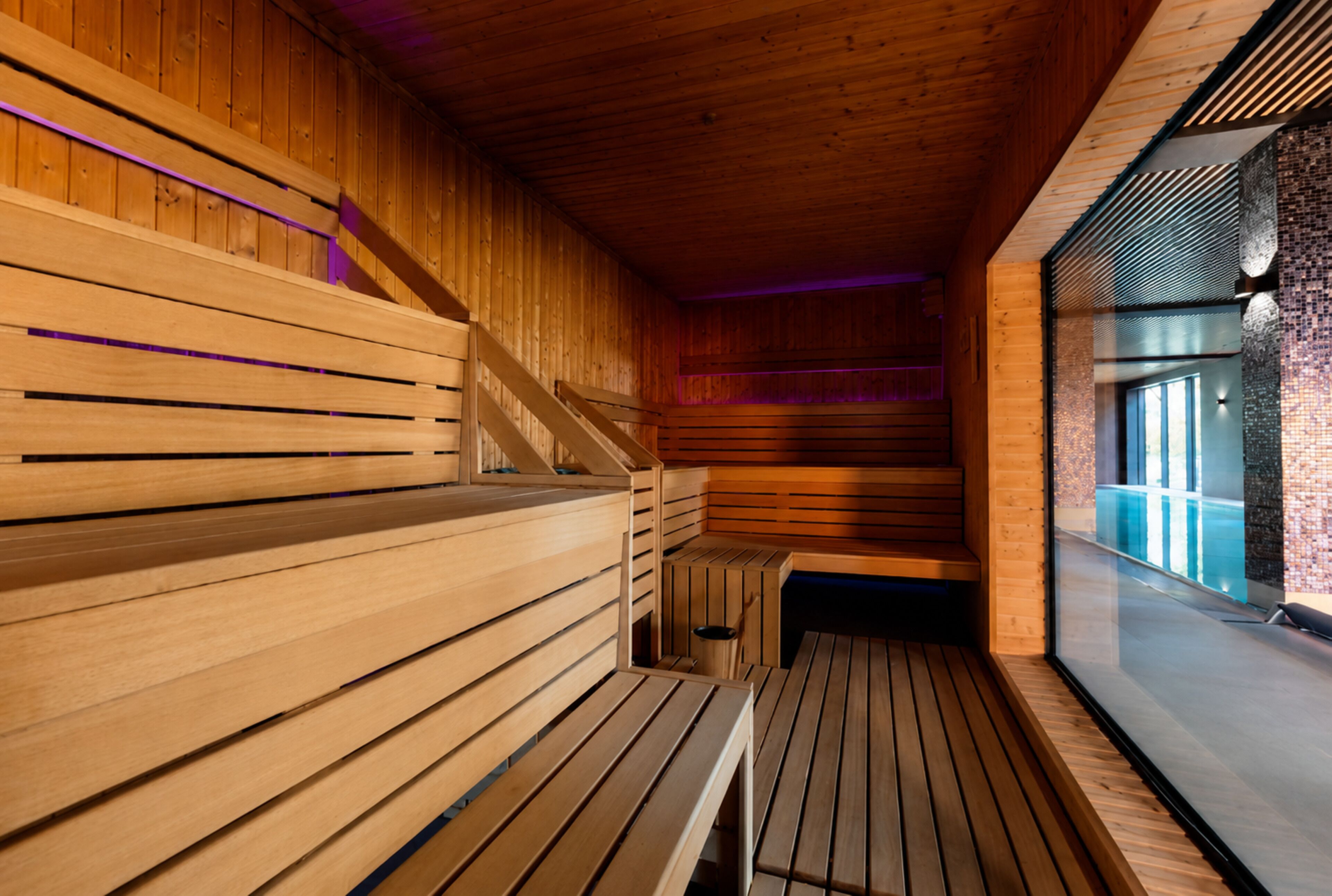 A sauna with wooden benches and a sloped ceiling.