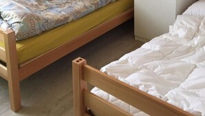 Ein Zimmer mit einem Etagenbett, einem Kleiderschrank und einem gerahmten Bild an der Wand.
