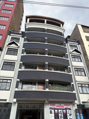 A multi-story building with balconies and a storefront advertising sound equipment.