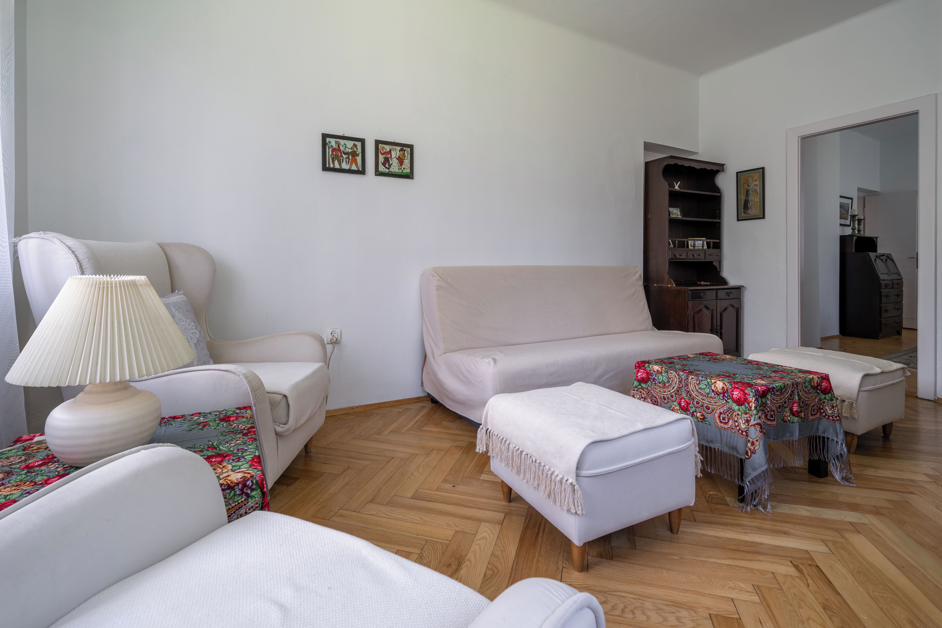 Un salon comprenant un canapé, des fauteuils, une table basse et une bibliothèque.