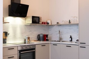 A modern kitchen with a built-in oven, microwave, and gas stove. - Modern Cocoon - Gare du Midi - BRO144.00 (Anderlecht)