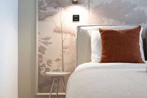 Ein Hotelzimmer mit einem Bett, einem Nachttisch und einer Wandleuchte.
