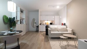 Un saló modern amb zona de menjador, cuina i un mirall gran.