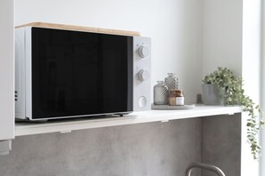 A microwave oven with a wooden top, placed on a white shelf. - Modern Cocoon - Gare du Midi - BRO144.2.1 (Anderlecht)