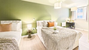 Une chambre avec deux lits, un bureau et une fenêtre.