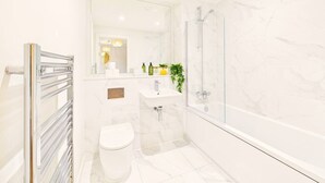 Une salle de bain moderne avec une douche à parois de verre, un lavabo blanc et des toilettes.