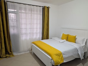 Ein Hotelzimmer mit Bett, Vorhängen und einem Fenster.