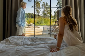 Un dormitorio con un ventanal grande, una cama y vistas a una terraza exterior.