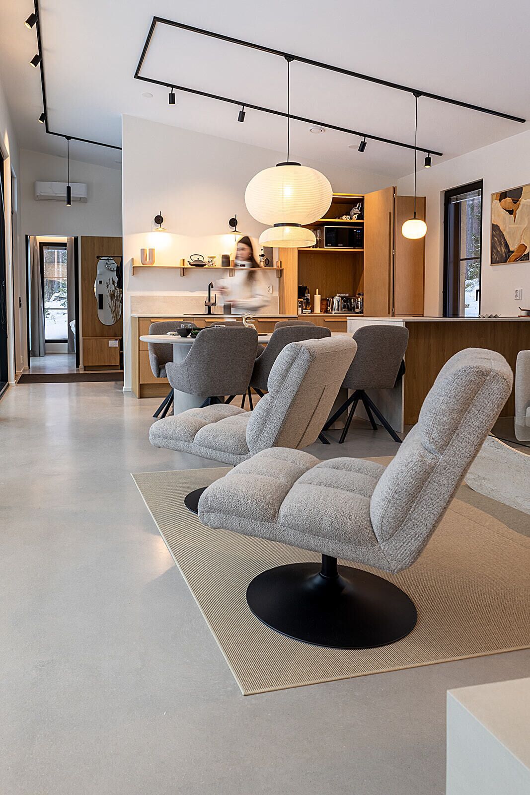Un salon moderne comprenant un ensemble de canapés, un coin cuisine et un espace repas.