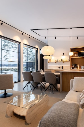 Un interior moderno con comedor, cocina y zona de estar.
