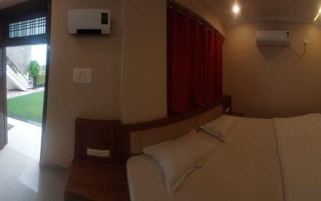 A bedroom with a bed, a TV, and a window with curtains.