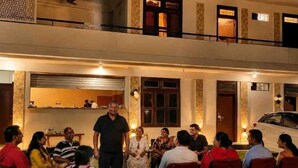 A multi-level building with a dining area on the ground floor and a balcony on the upper level. - Rangoli Garden Homestay (Varanasi)