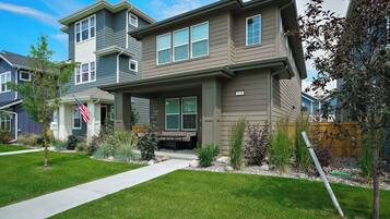 A two-story residential house with a front porch, a mailbox, and a well-maintained lawn.