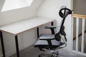 Een hoekbureau met een bureau en een ergonomische stoel.