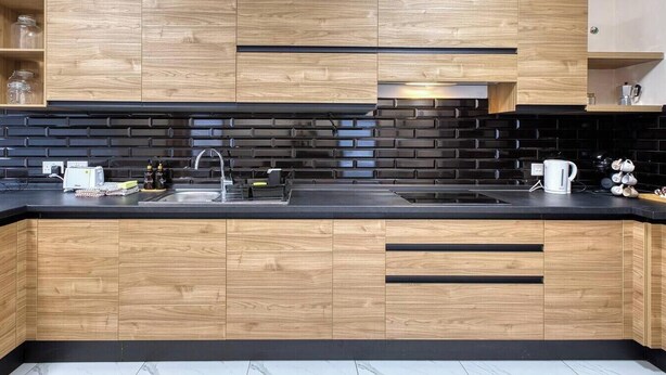 A modern kitchen with wooden cabinets, a black backsplash, and a black countertop. - Bright Modern, fully equipped 3BR home w/AC & WIFI (Birkirkara)