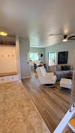A spacious living area with a dining table and chairs, a sofa, and a ceiling fan. - 4BR Furnished Home in Waikoloa Village. Private Gym + Back Yard Entertainment (Waikoloa Village)