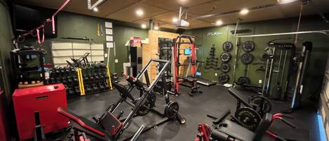 Une salle de sport équipée de divers appareils d’entraînement, notamment des machines à poids et des poids libres.