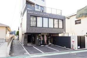 En modern byggnad med en skylt som visar texten "AMP FLAT ARCBLISS".