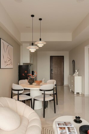 A modern dining area with a round table, chairs, and pendant lighting. - Corner 2BR/3Beds • River View • Walk to Bui Vien (Thành phố Hồ Chí Minh)