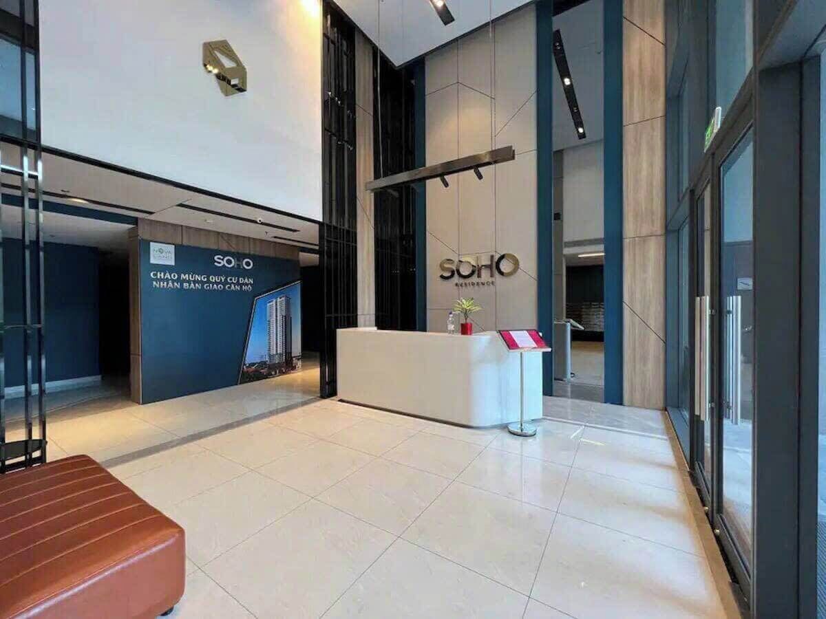 A reception area with a reception desk, a seating area, and a wall with a sign.