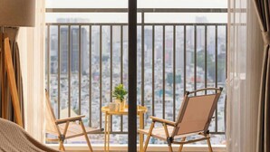 A hotel room with a large sliding glass door leading to a balcony with a city view. - High-Rise | 2Br+1Wc | Central | D1 | 1min BuiVien (Thành phố Hồ Chí Minh)