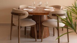A dining area with a round wooden table, six chairs, and a hanging light fixture. - High-Rise | 2Br+1Wc | Central | D1 | 1min BuiVien (Thành phố Hồ Chí Minh)