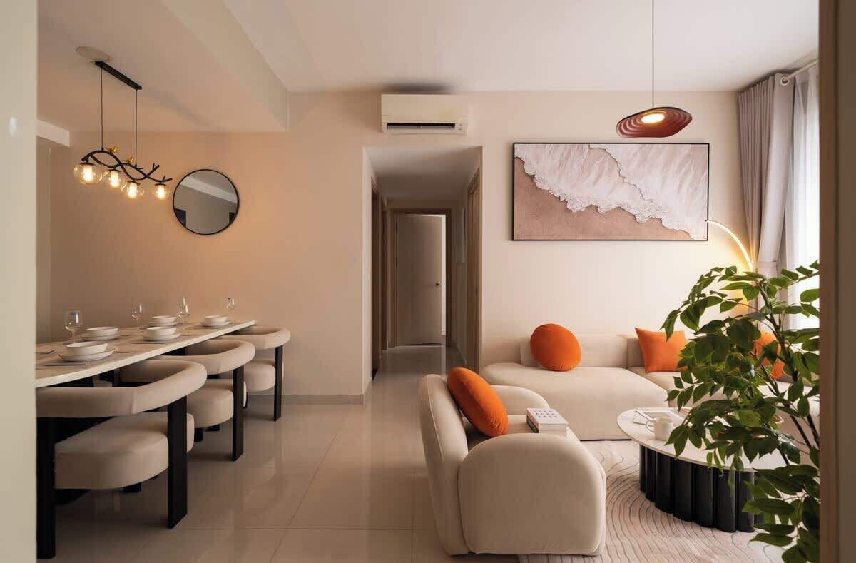 Una sala de estar moderna con un sofá, una mesa de centro y una zona de comedor con una mesa dispuesta para cuatro.