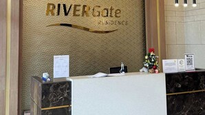 Ein Empfangstresen mit einem Schild, auf dem 'RIVERGate Residence' steht.