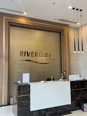 A reception desk with a sign that reads 'RIVERGate Residence.' - Minimalist Cozy 3BR/2BA • D1 Center• 200m Bui Vien (Thành phố Hồ Chí Minh)