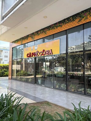 A café with a large glass storefront and outdoor seating. - Minimalist Cozy 3BR/2BA • D1 Center• 200m Bui Vien (Thành phố Hồ Chí Minh)