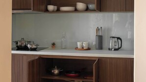 Una cucina con pensili e mobili in legno, un piano di lavoro e diversi utensili da cucina.