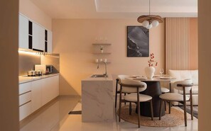 Eine moderne Küche mit Marmorarbeitsplatten, einem eingebauten Backofen und einem Essbereich mit rundem Tisch und Stühlen.